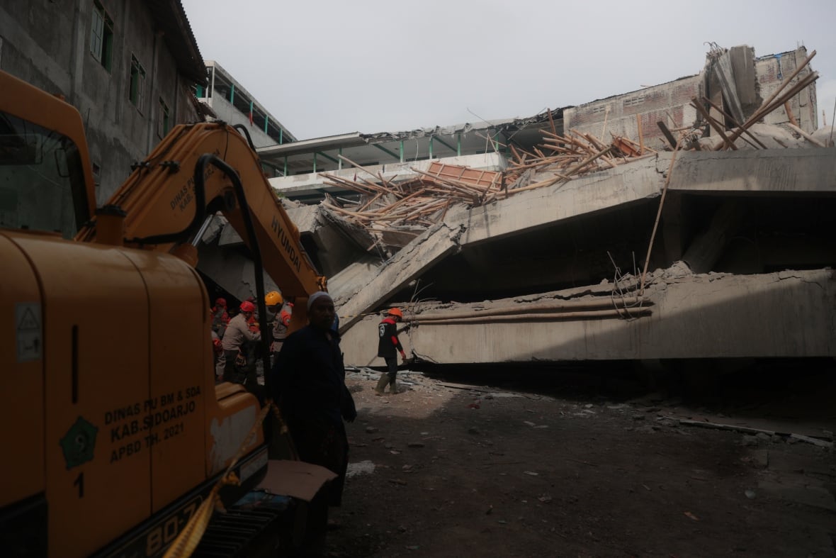 Rescue workers work in the location of the collapsed building