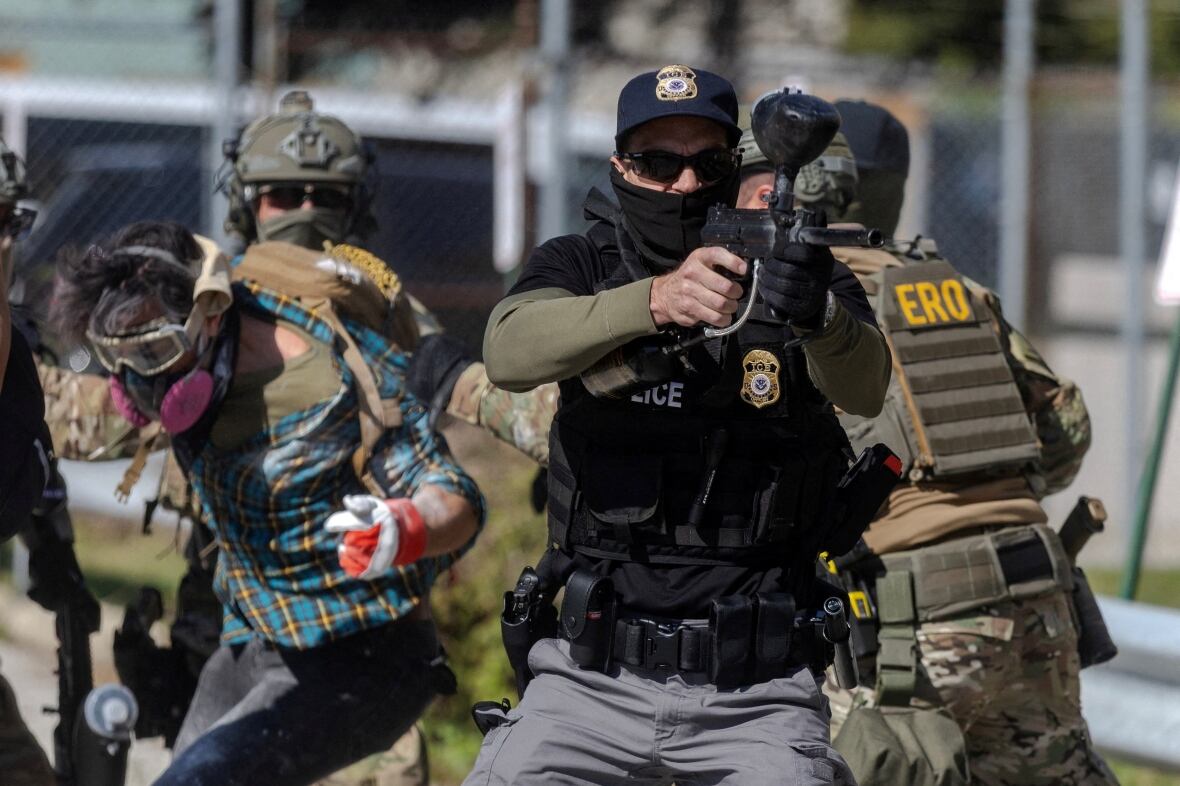 The authorities arrest the protesters behind as a state agent hold of what looks like a projectile weapon from others. 
