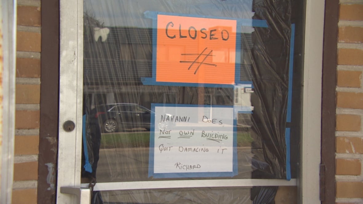 Glass door with bright orange closed sign in the window
