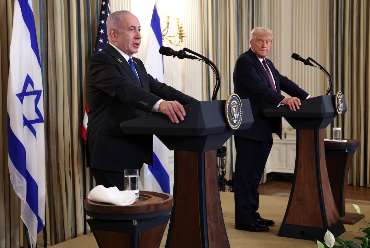 Two men in suits stand at wooden podiums with the presidential seal. They are flanked by Israeli flags. 