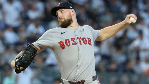A left-handed men's baseball pitcher throws a baseball.