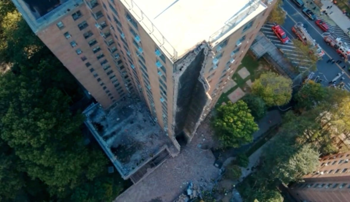 A building is seen from above with part of its siding detached.