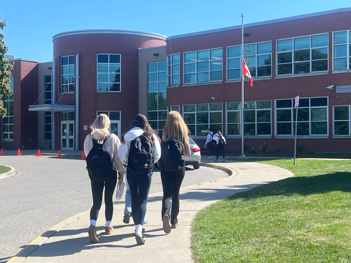 Los estudiantes de Medway High School caminan junto a la bandera que se bajó para honrar a Gavin DeClark el martes 30 de septiembre de 2025.
