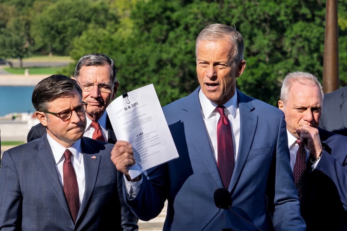 Four Caucasian men are displayed in Kolshevin wearing a suit and an outdoor tie near the microphone. One man holds a document.