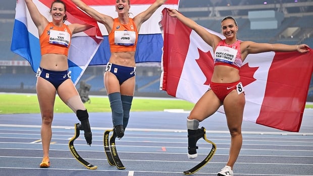 From left: Gold medallist Fleur Jong, her Dutch teammate and silver medallist Marlene van Gansewinkel and bronze medallist Marissa Papaconstantinou of Canada pose for a photo following the women's 100-metre T64 final at the Para athletics world championships on October 1, 2025 in New Delhi, India. 