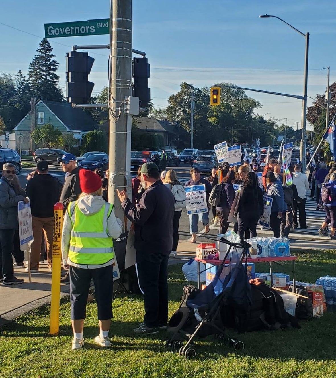 A picket line on a sidewalk of a street called Governor's Boulevard. 