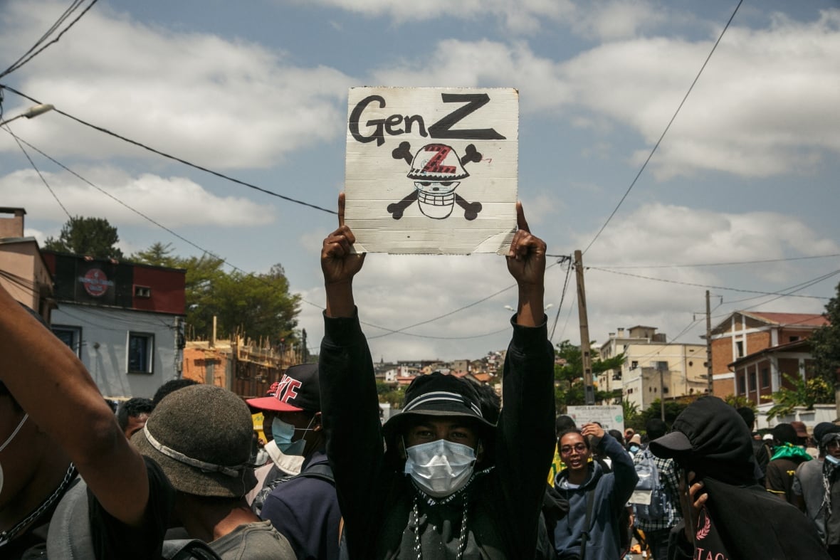 Street protesters, one holding a sign-meaning sign "gen z"