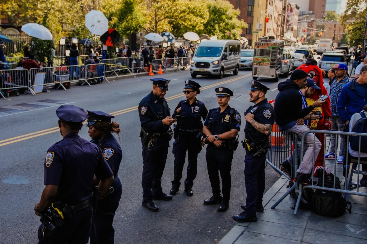 A group of policemen stands on the street.