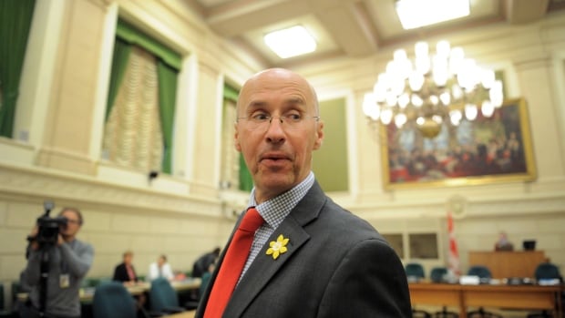 A man in a suit and tie looks over his left shoulder.