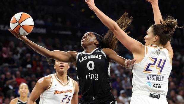 Jackie Young of the Las Vegas Aces shoots the ball between Alyssa Thomas and Kathryn Westbeld of the Phoenix Mercury in the first quarter of Game 2 of the WNBA Finals on October 05, 2025 in Nevada.