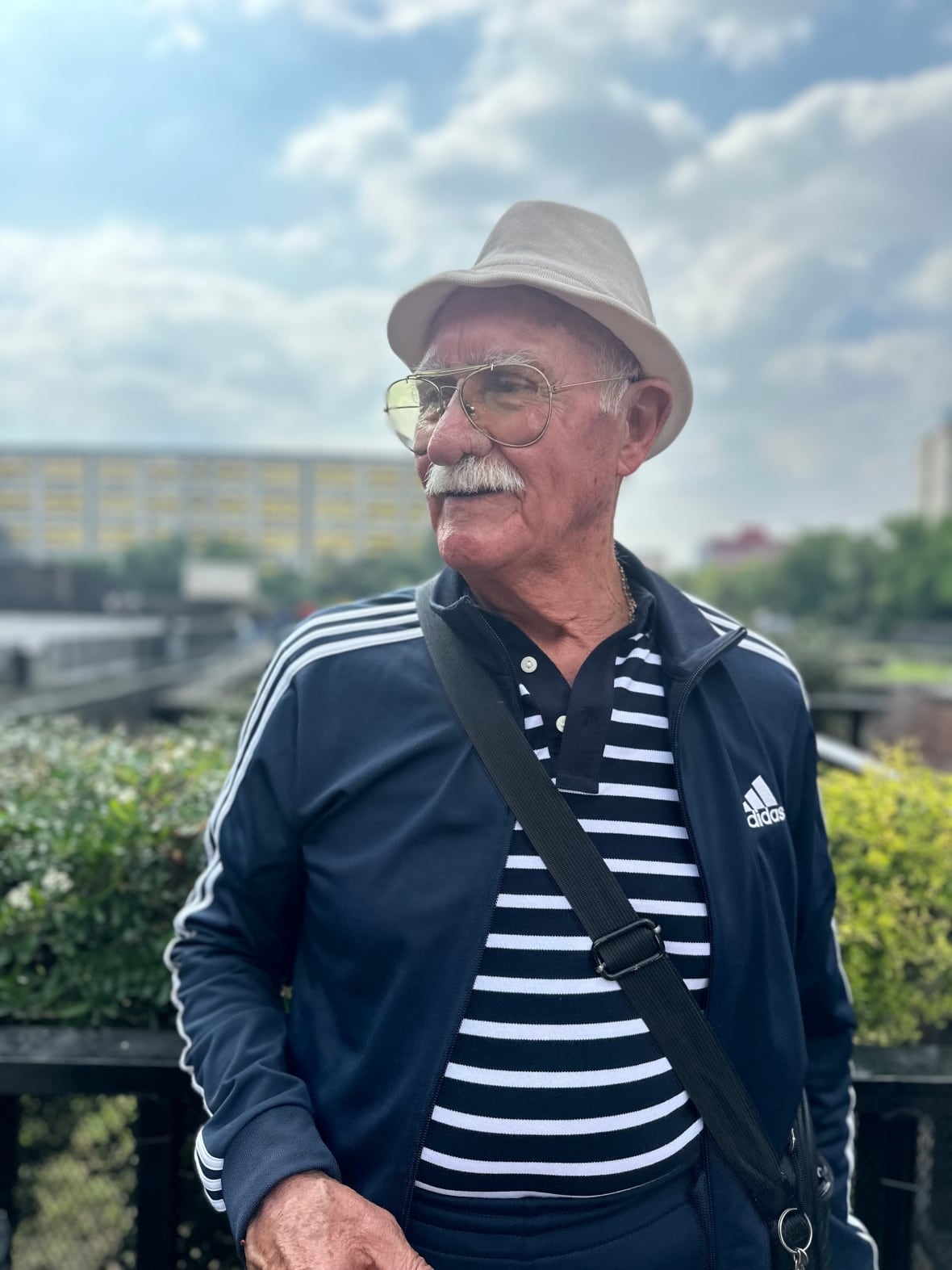 An old man in a hat and glasses look on the side