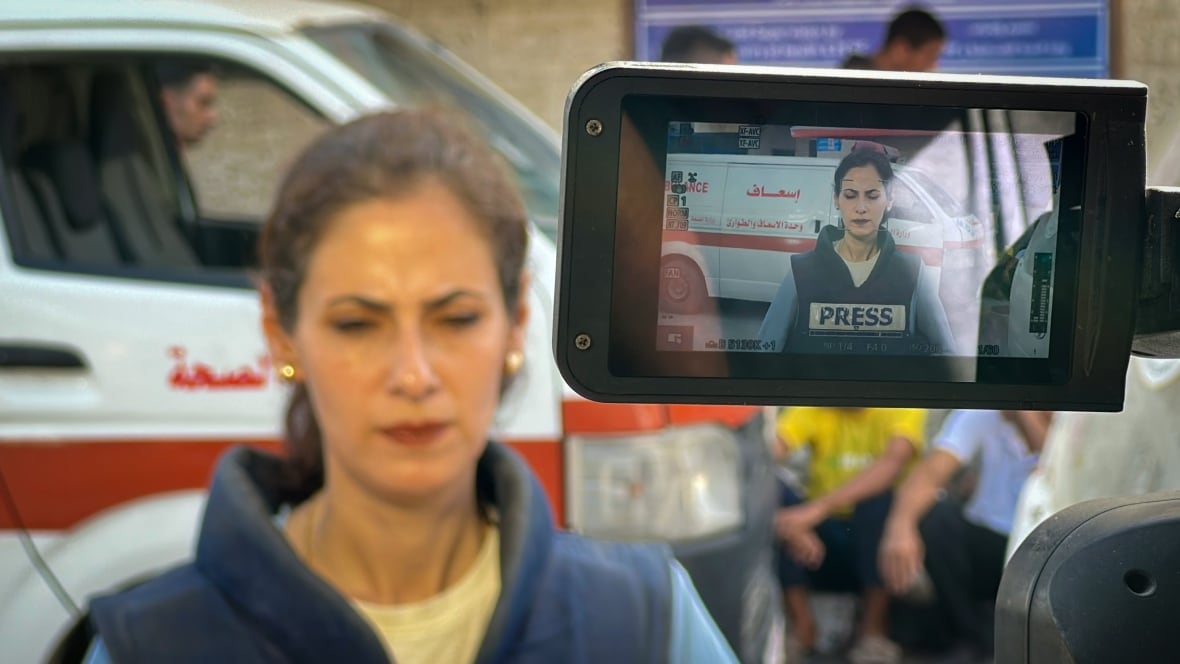 A correspondent is filmed through the camera lens.