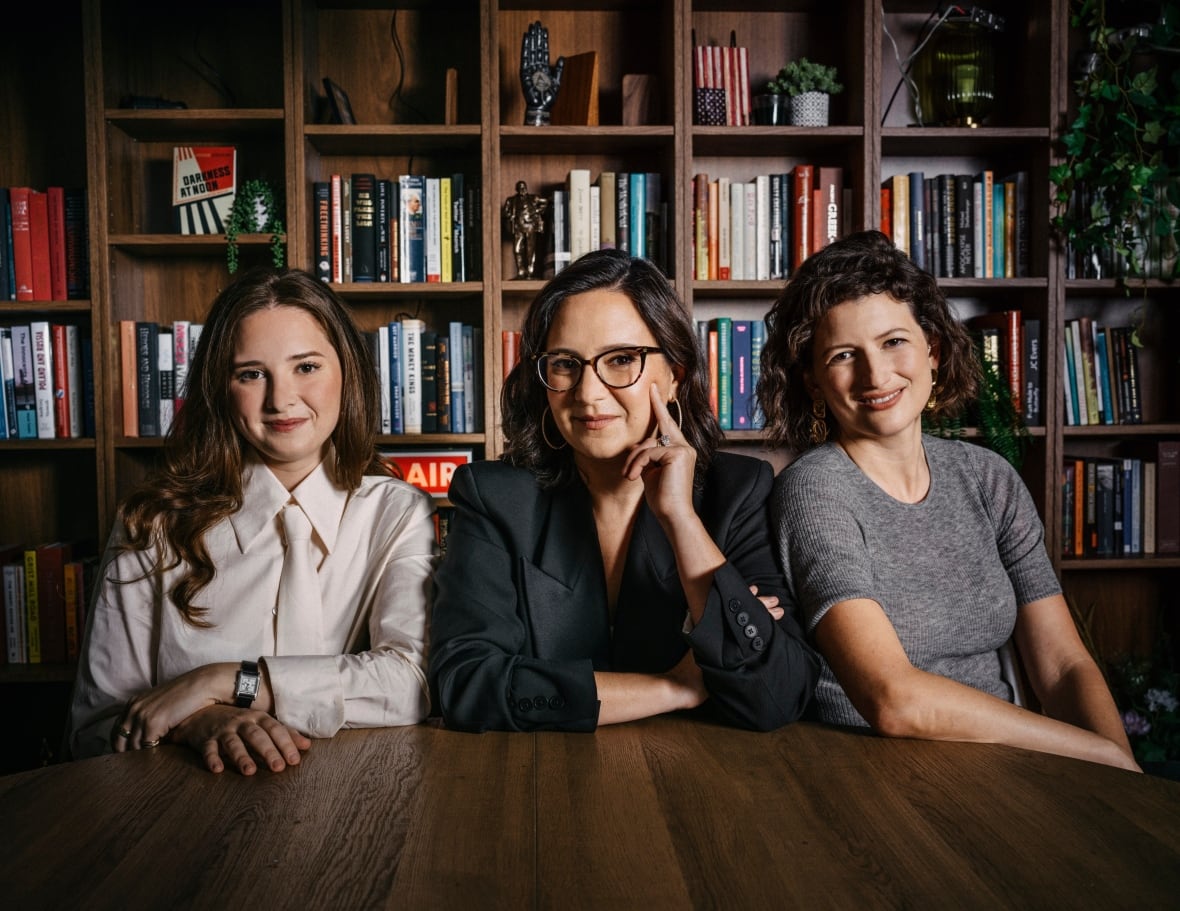 Three women put in front of the books shelf