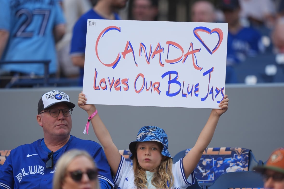 Toronto Blue Jay Fan catches a sign read "Canada likes our blue jay."