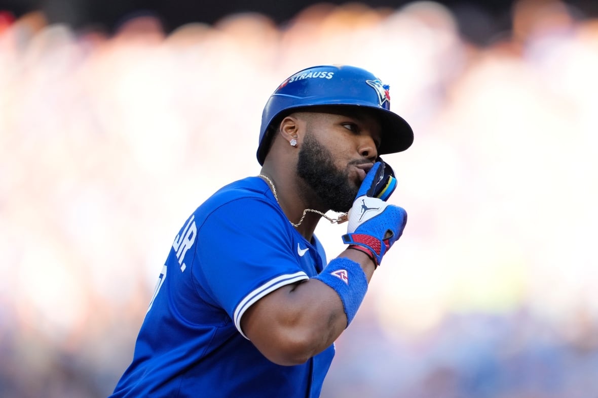 Un jugador de béisbol señala hacia arriba.
