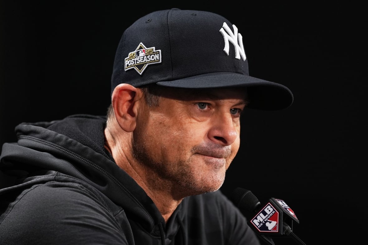 Un hombre con una gorra de béisbol, sentado frente a un micrófono.