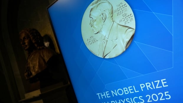 A large blowup of a gold coin with the portrait of a man is shown, with the inscription underneath, 