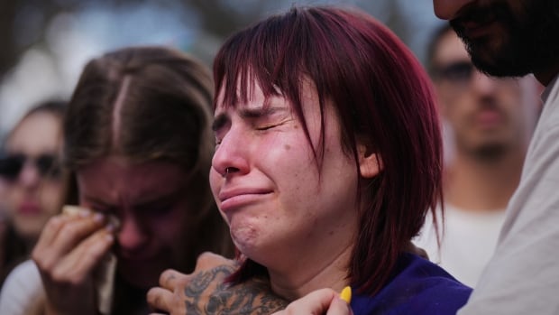People cry in a crowd.