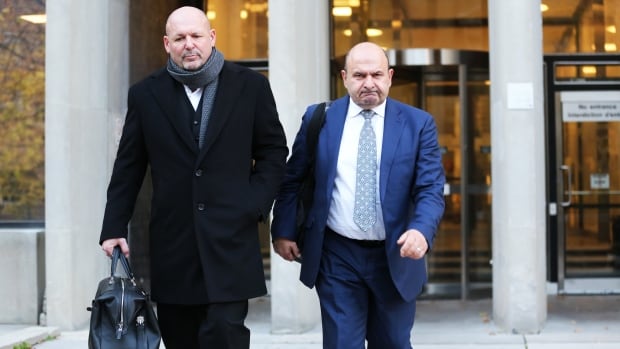 TORONTO, ON - November 12, 2024 Former St. Michael's Hospital executive Vas Georgiou (right) and his lawyer are seen outside a Toronto court on Tuesday, November 12. Day one of a fraud trial connected to a $316-million contract with St. Michael's Hospital. The case involved allegations construction firm Bondfield's former CEO John Aquino worked with St. Mike's former chief administrative officer Vas Georgiou to secure insider information and obtain the contract. The case also involves allegations Aquino blackmailed Bonfield's former CFO Domenic Dipede. Two men walking out of a courthouse.