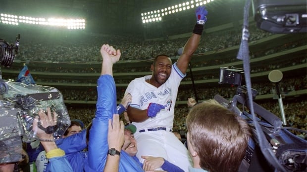 A man on celebrates on the shoulders of teammates. 