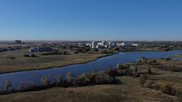 An aerial photo of campus buildings surrounded by green space and wetlands on a sunny fall day.