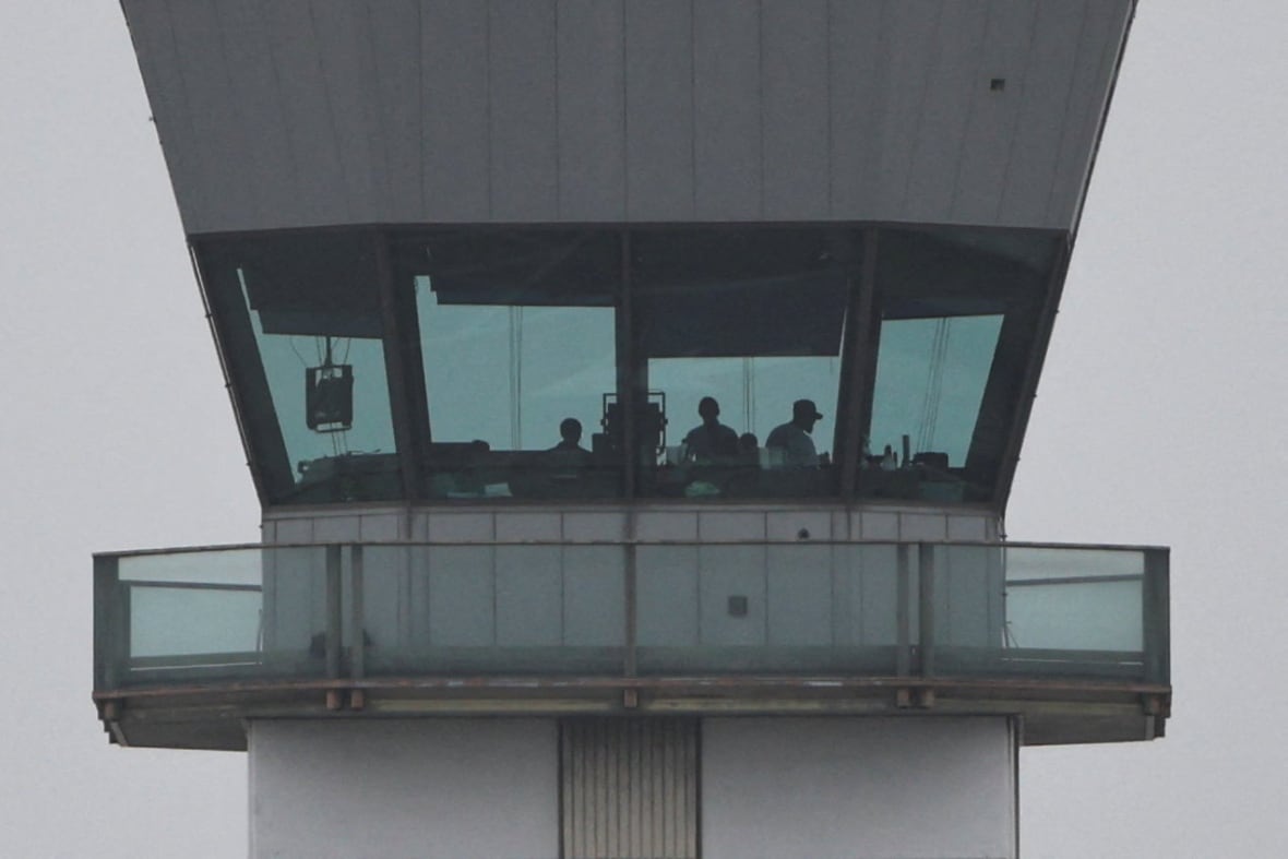 Silhouettes of people working in a large building