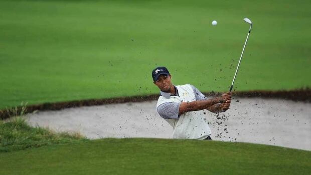 Tiger Woods drops his ball after he hits it into the water on the 15th hole during the second round of the 2013 Masters at Augusta National Golf Club on Saturday in Augusta, Ga.