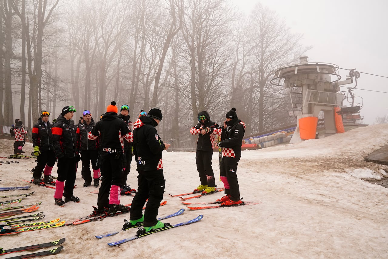 Workers are shown skiing in foggy weather.