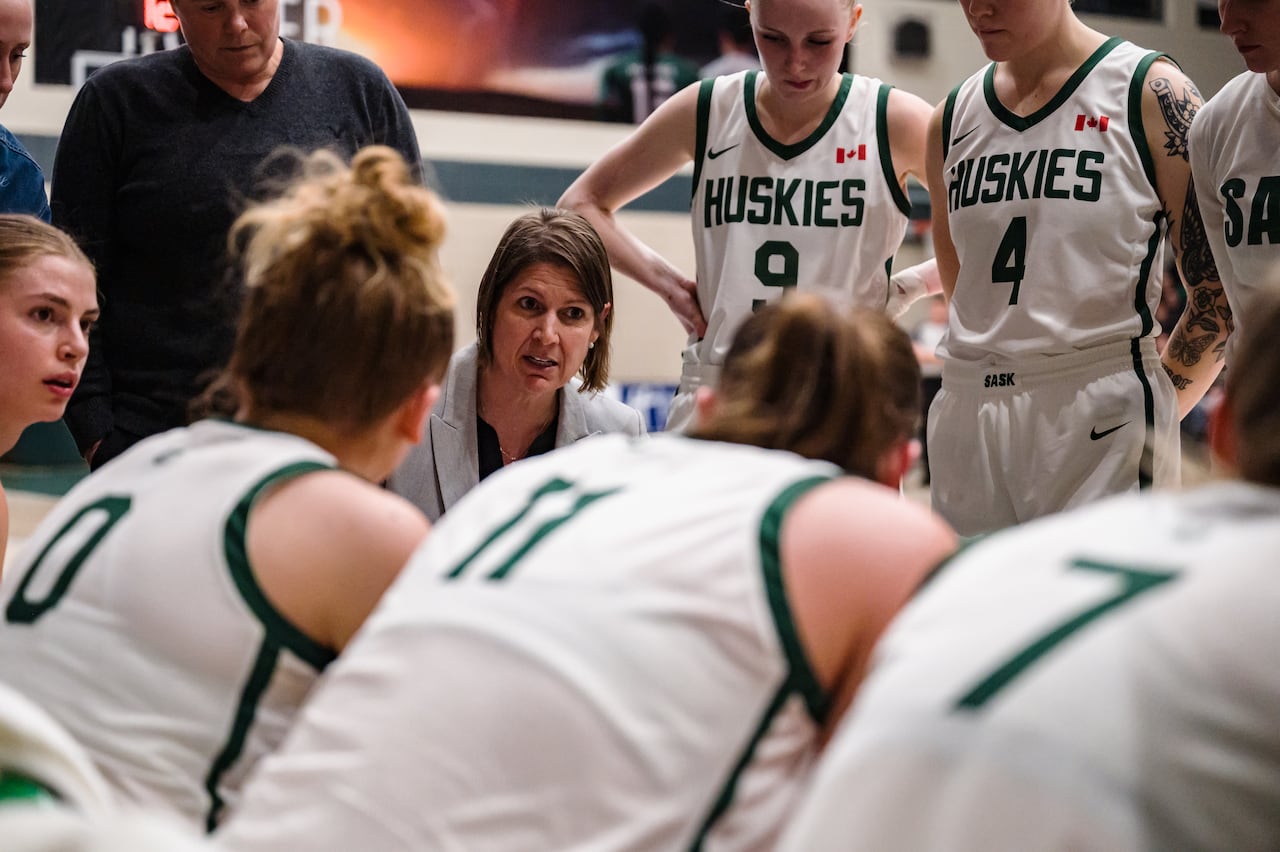 The basketball coach talks with the players.