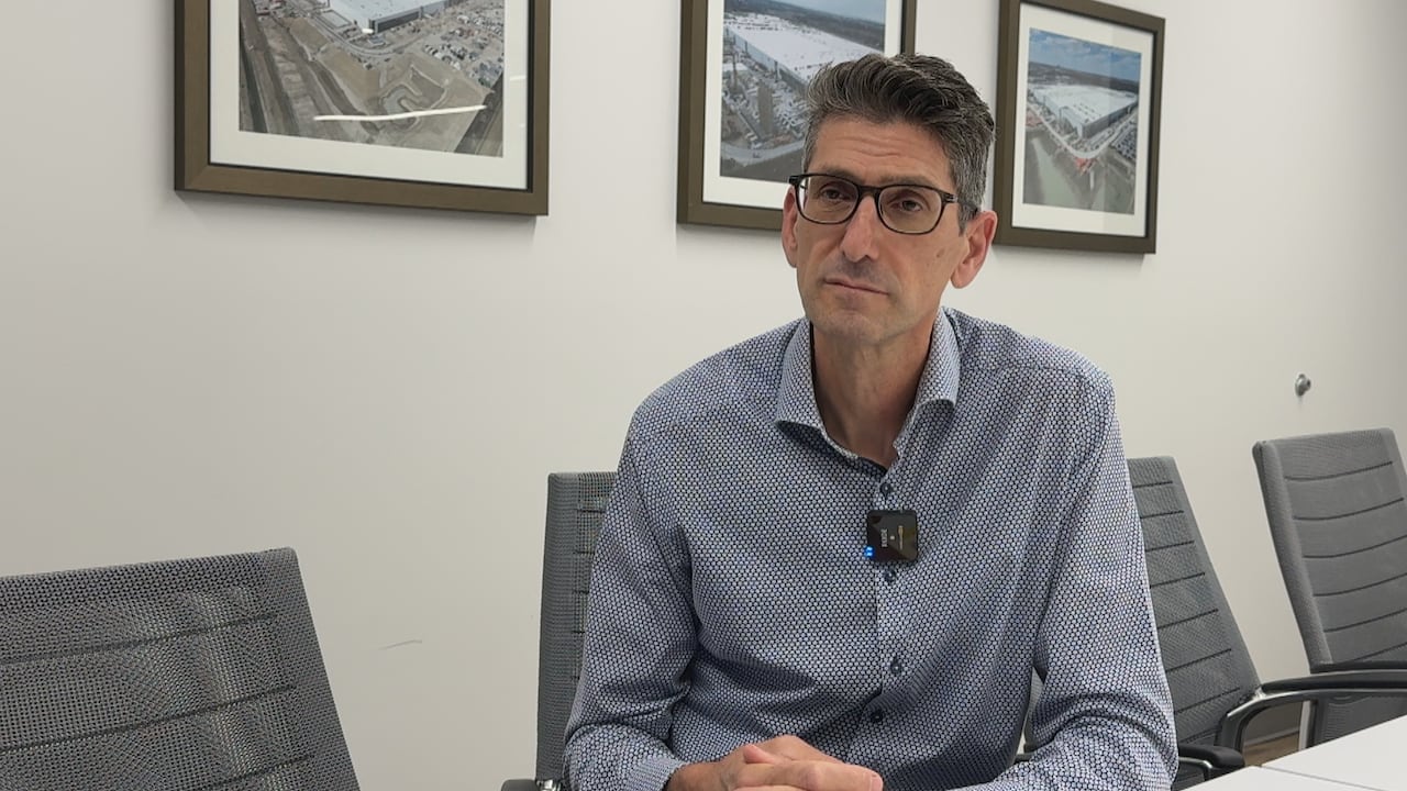 Man with crossed hands sits astatine a seat astatine a boardroom table.