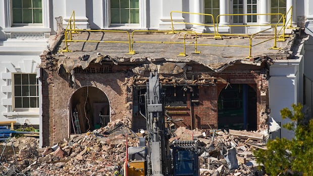 Debris is seen at a largely demolished part of the East Wing of the White House, Thursday, Oct. 23, 2025, in Washington, before construction of a new ballroom.  A construction machine moves debris as a large pile is shown near the side of a building.