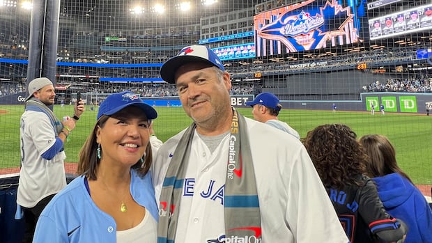 A man and woman in Blue Jays caps and shirts inside SkyDome