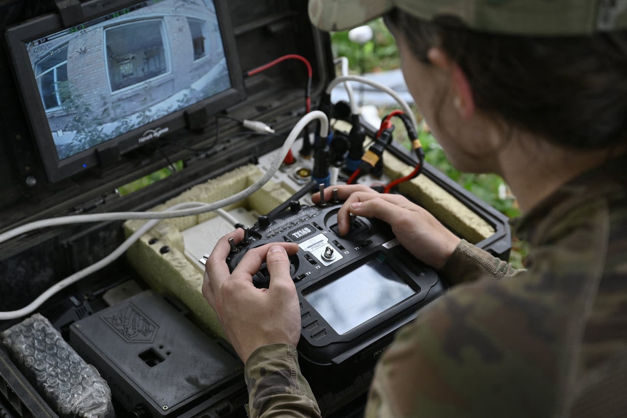 A soldier uses a drone, view of the drone's camera feed on a small monitor