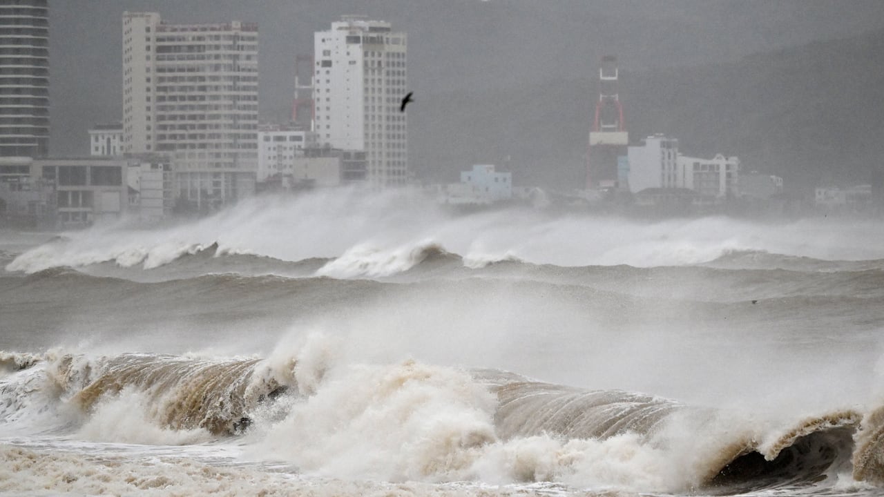 Significant waves successful  a assemblage  of h2o  are shown connected  a dreary-looking time  with high-rises successful  the background.