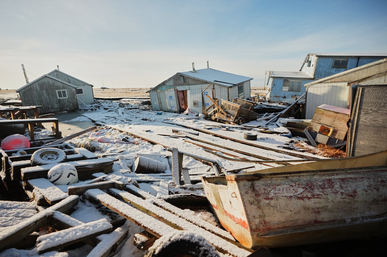 Ramshackle homes surrounded by debris.