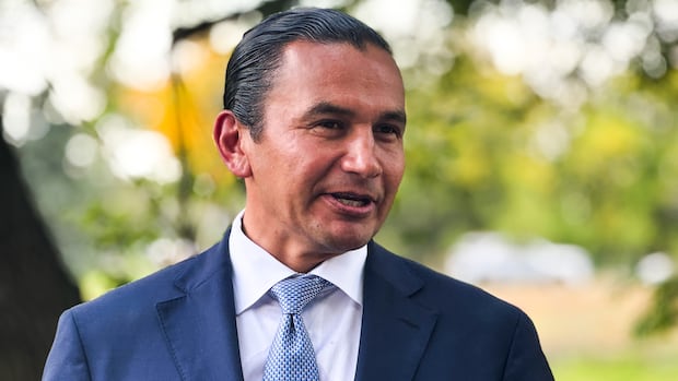 A man with dark hair and a blue blazer and tie.