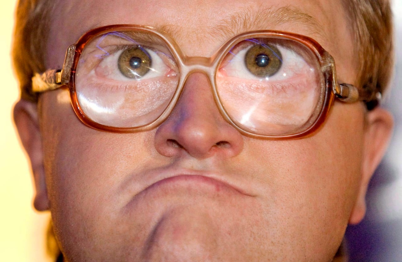 A close-up photo of a man wearing thick glasses.