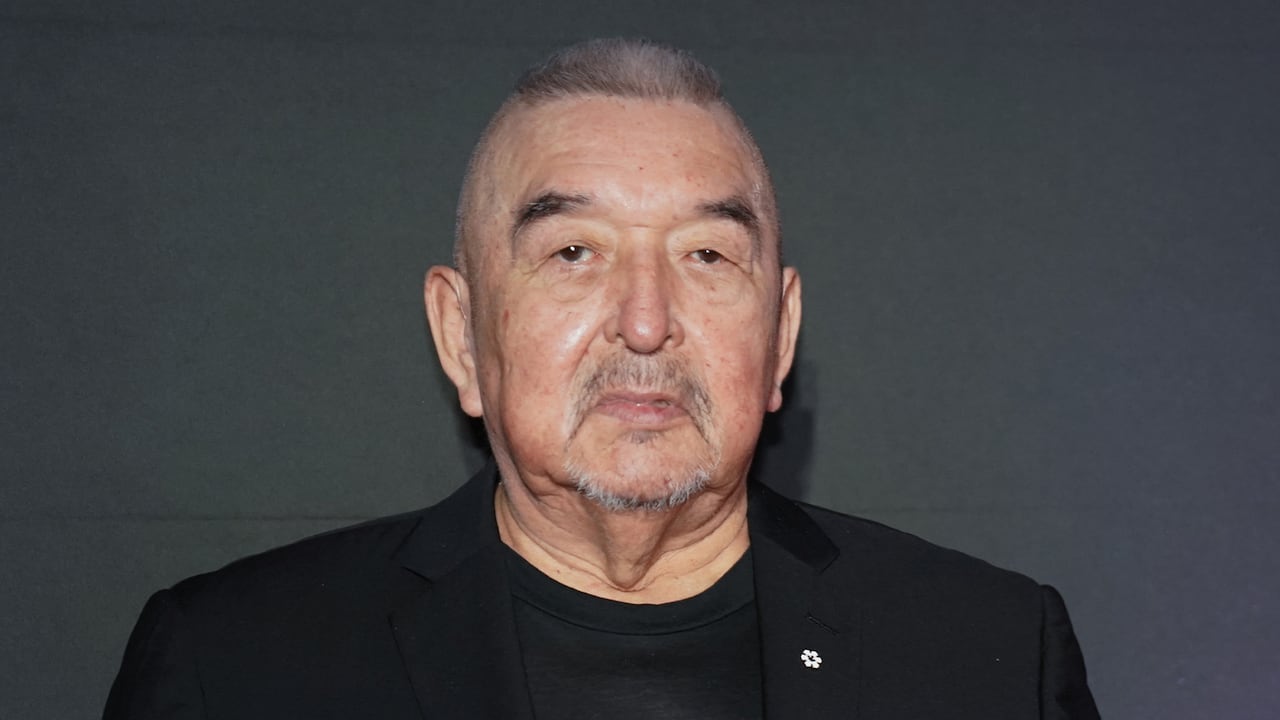 An older man poses for a photo. 