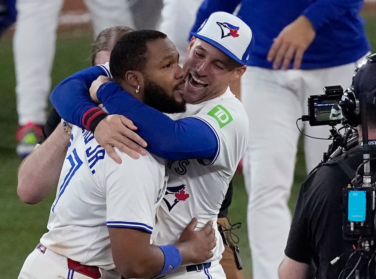 Two baseball players celebrating a win on the field