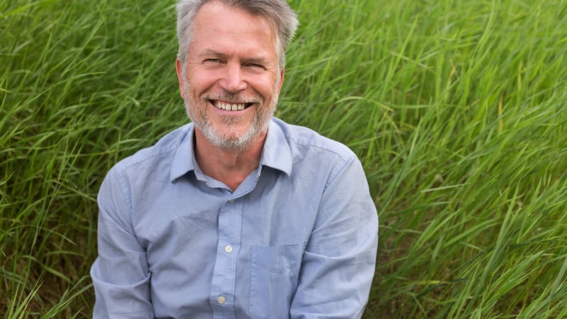 A man smiling in tall grass