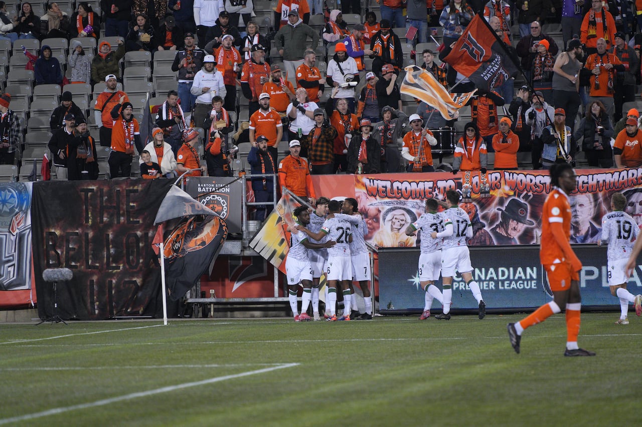 Soccer/football players observe  connected  the field.