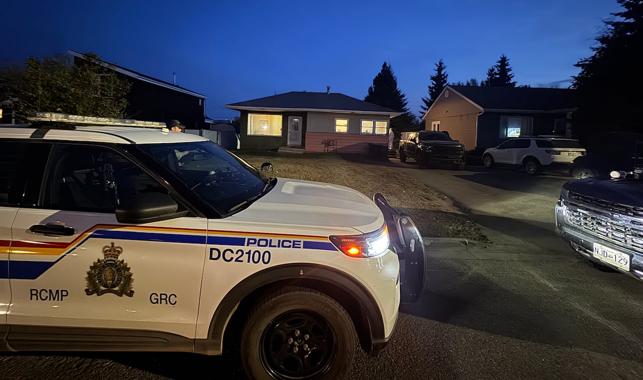 RCMP vehicles surround a house at night