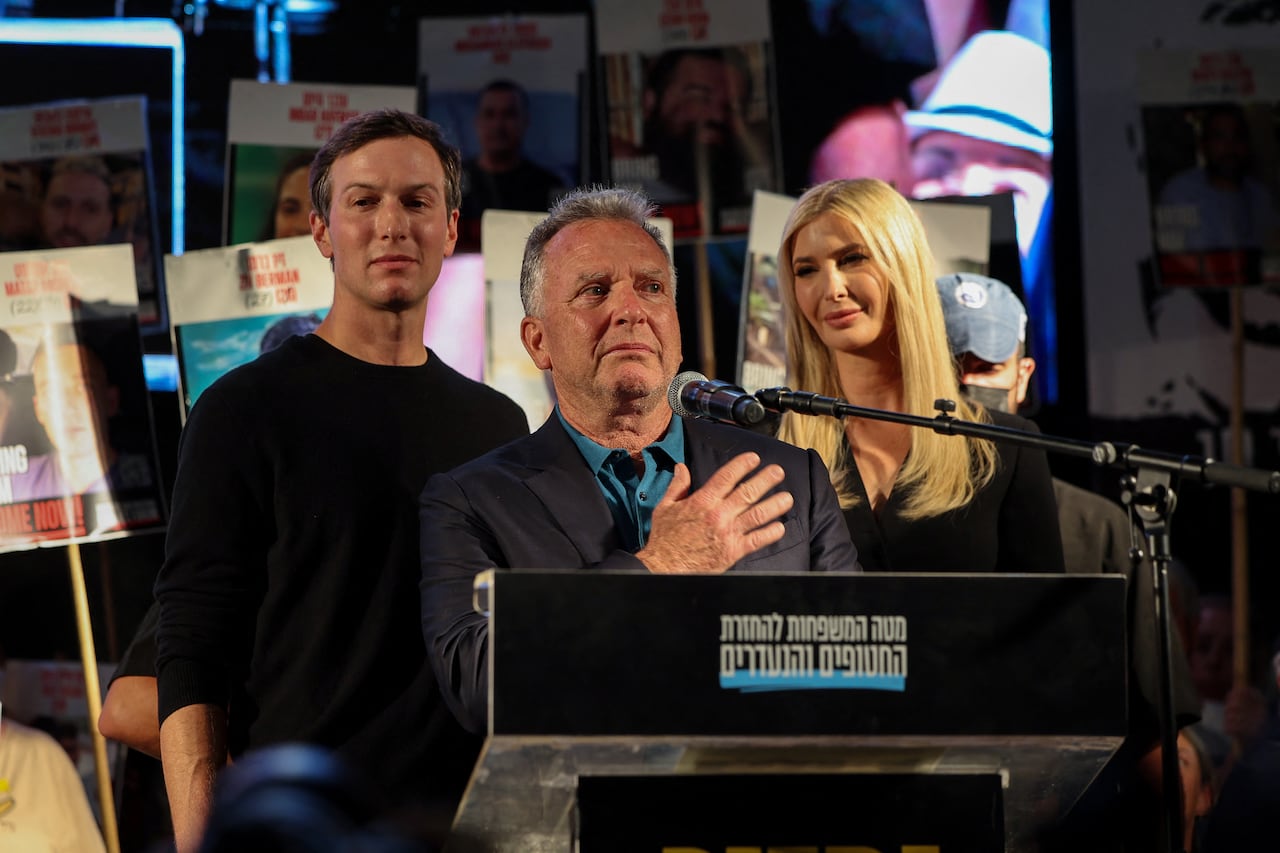 Three people are seen behind a lectern.