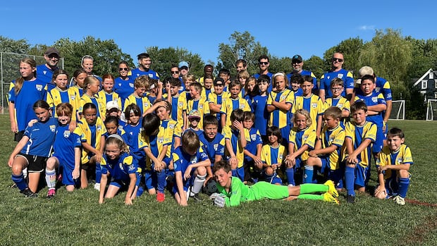 A soccer team of children pose for a group photo