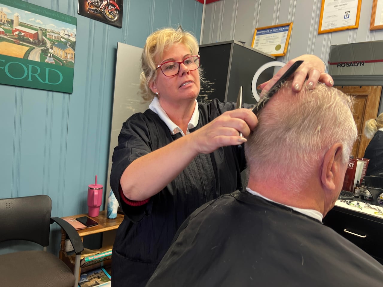 A woman cuts hair at a barbershop in Ingersoll, Ontario.