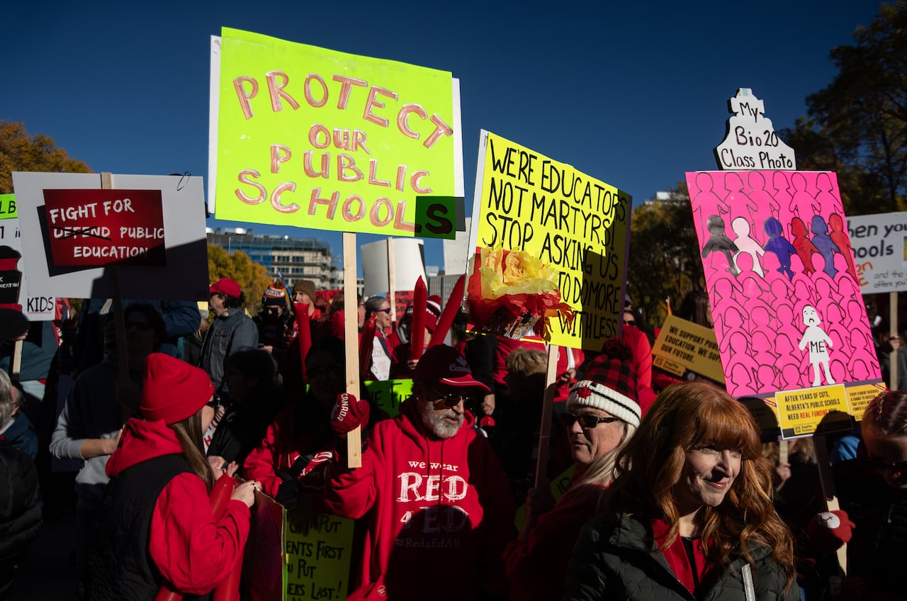 People hold placards at a rally
