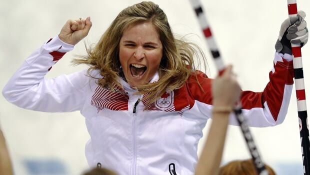A woman celebrates on a curling rink.