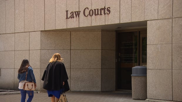 The Manitoba Law Courts Building in Winnipeg. Two women are seen walking into a law court building.