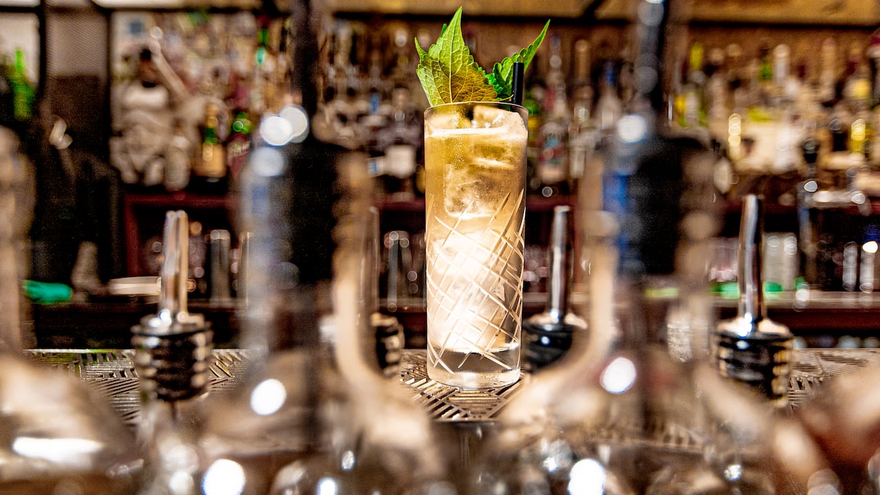 A drink sits on a bar.