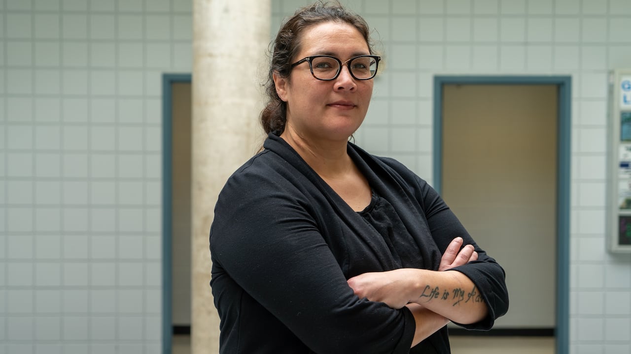 A young pistillate with glasses with her arms crossed.